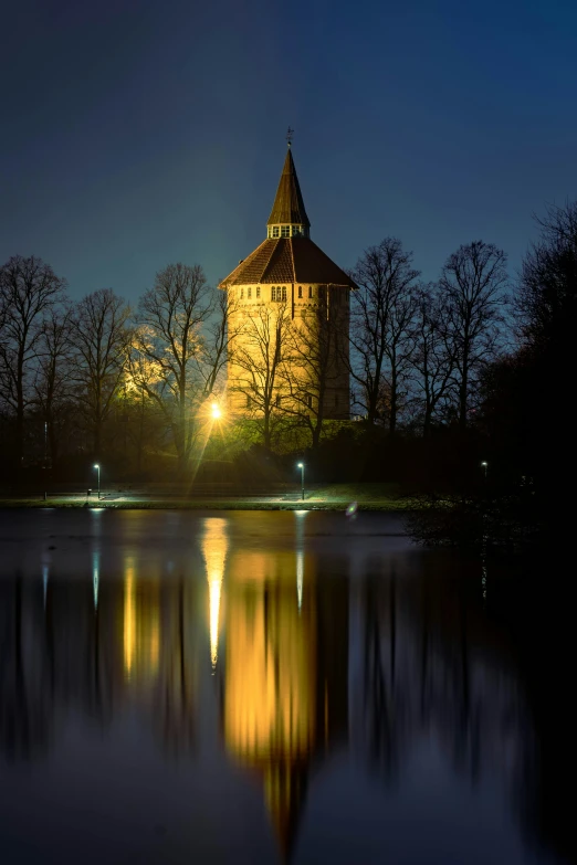 a tall tower sitting above a body of water at night