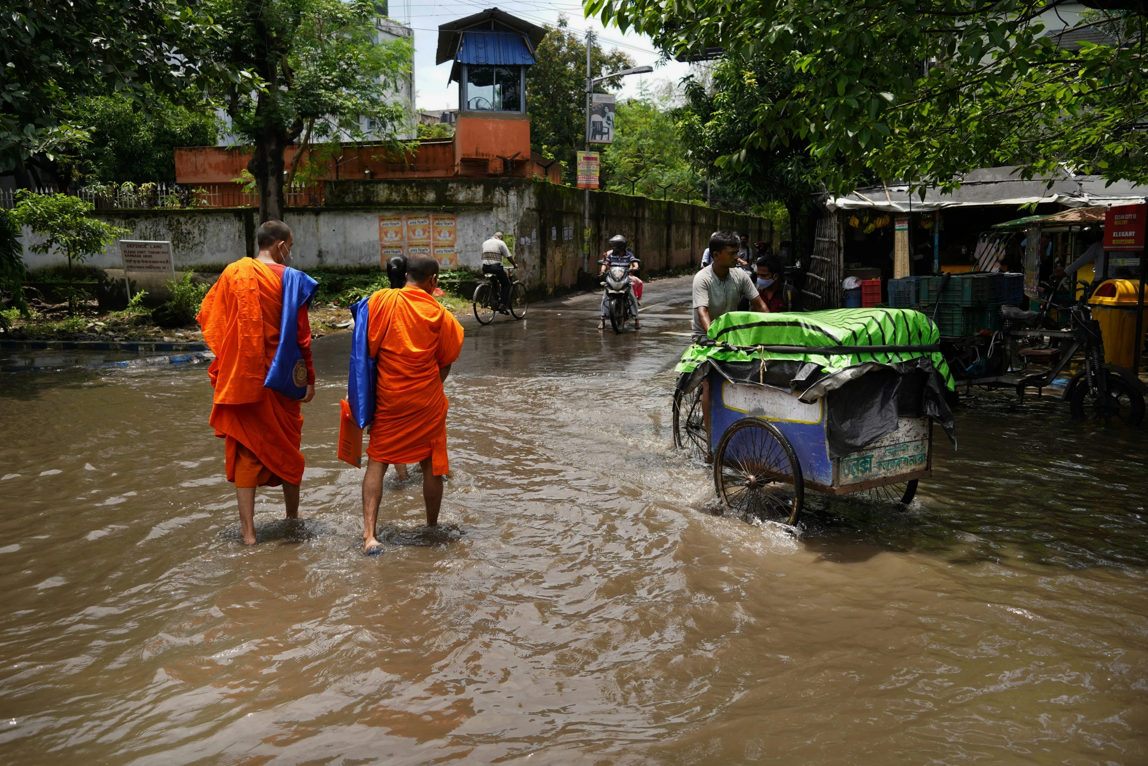 two monks walking through a flooded street