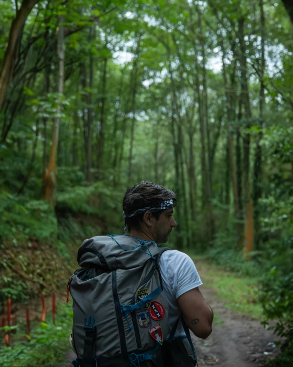 a man with backpack hiking in a forest