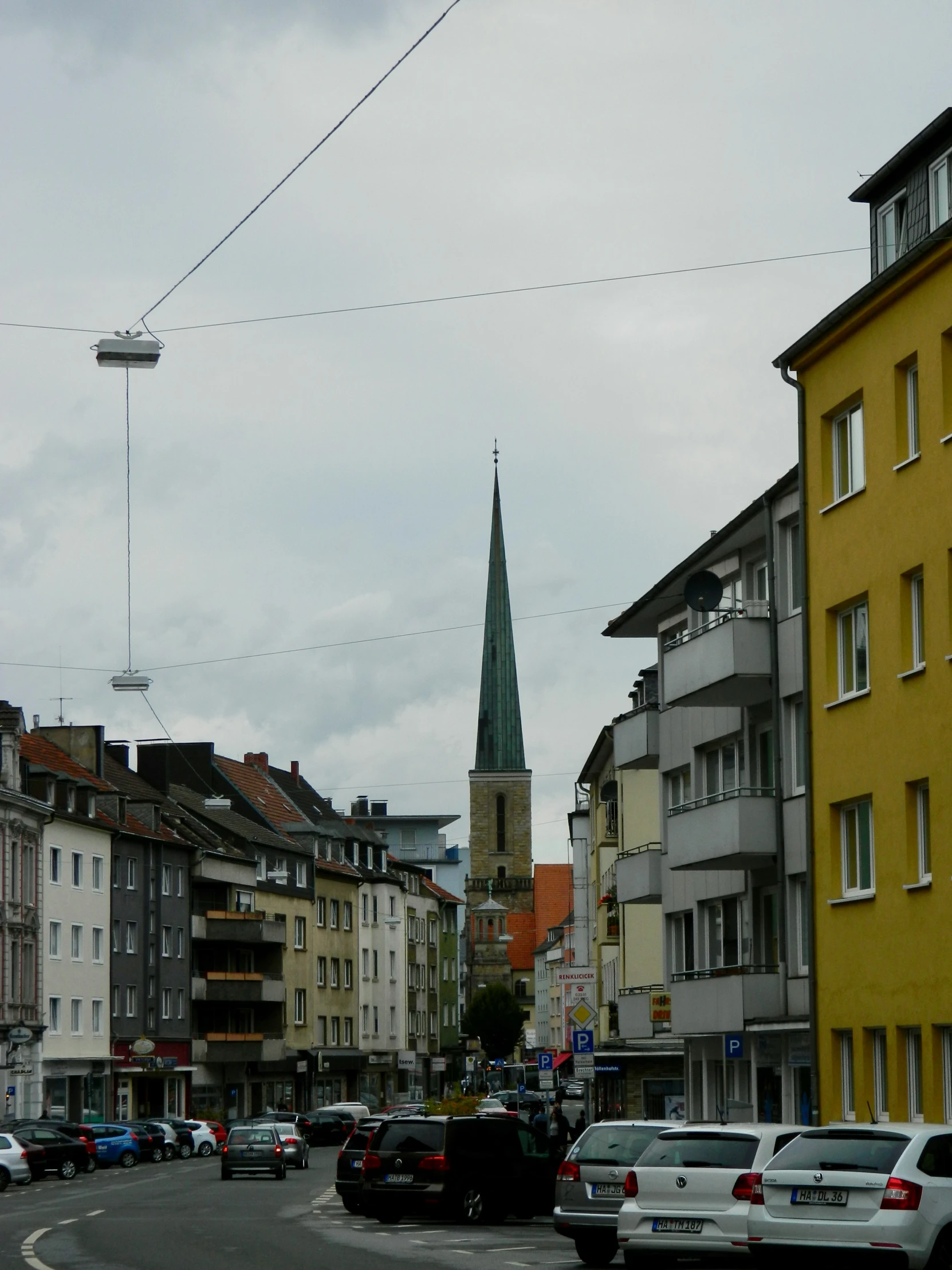 a street filled with lots of traffic and a church tower towering over the city