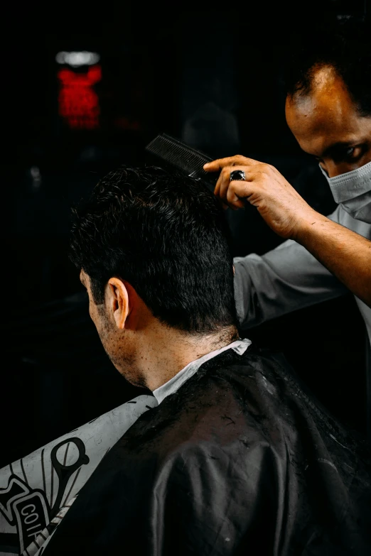 a man getting his hair cut with scissors