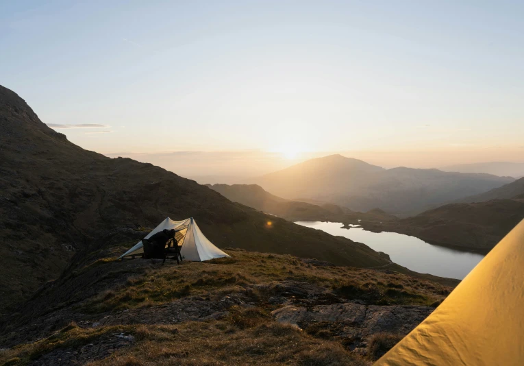 a couple tents pitched on the side of a mountain