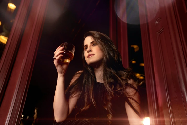 a woman in black dress holding a glass of wine