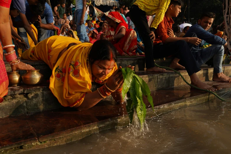 a woman laying on the ground on the side of a river