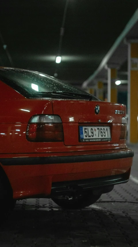 a red car is parked in an underground parking lot