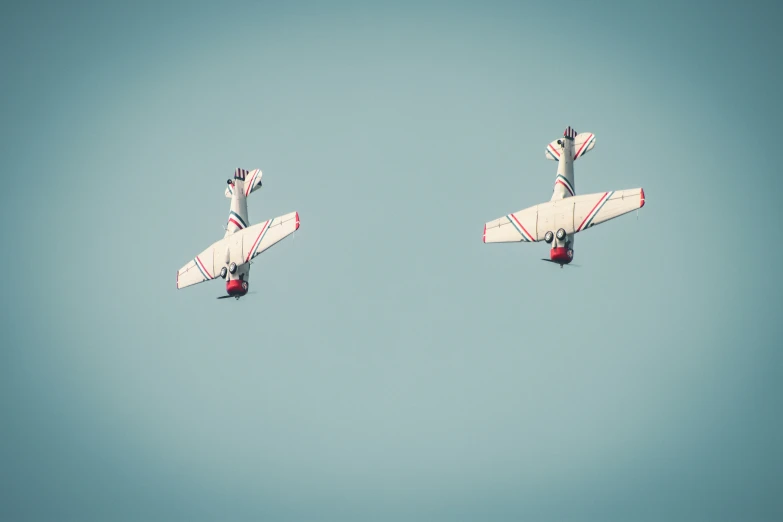 two airplanes flying in the air above each other