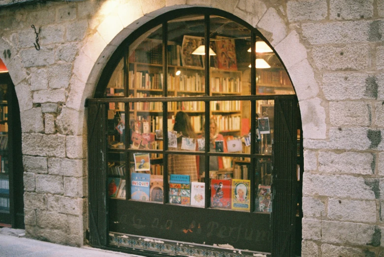 there is a storefront with many books on the windows