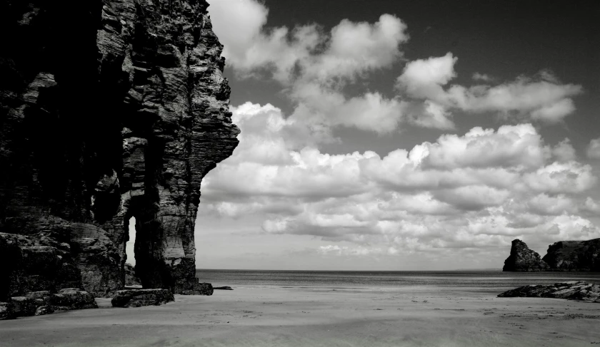 black and white po of a beach and rocky cliff