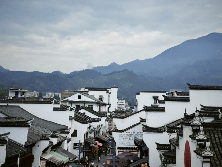 a few buildings with hills behind them and mountains in the distance