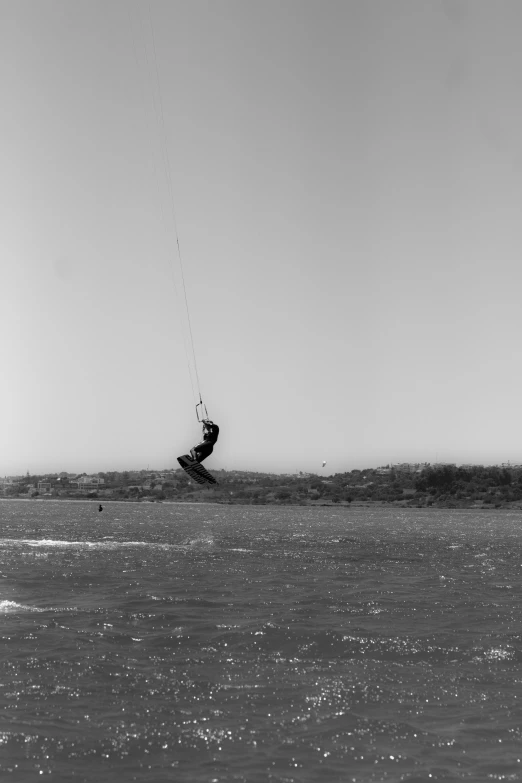 man parasailing in open waters, against clear sky