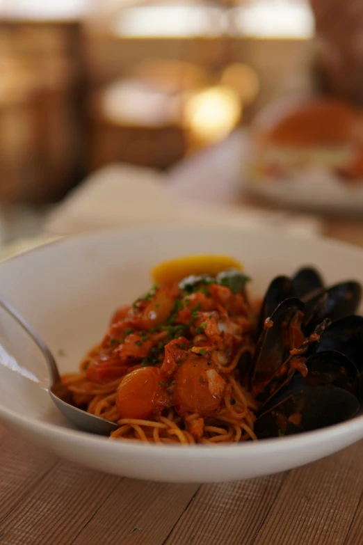 a bowl of pasta with mussels and sauce