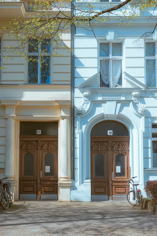 two brown doors on a white and blue building