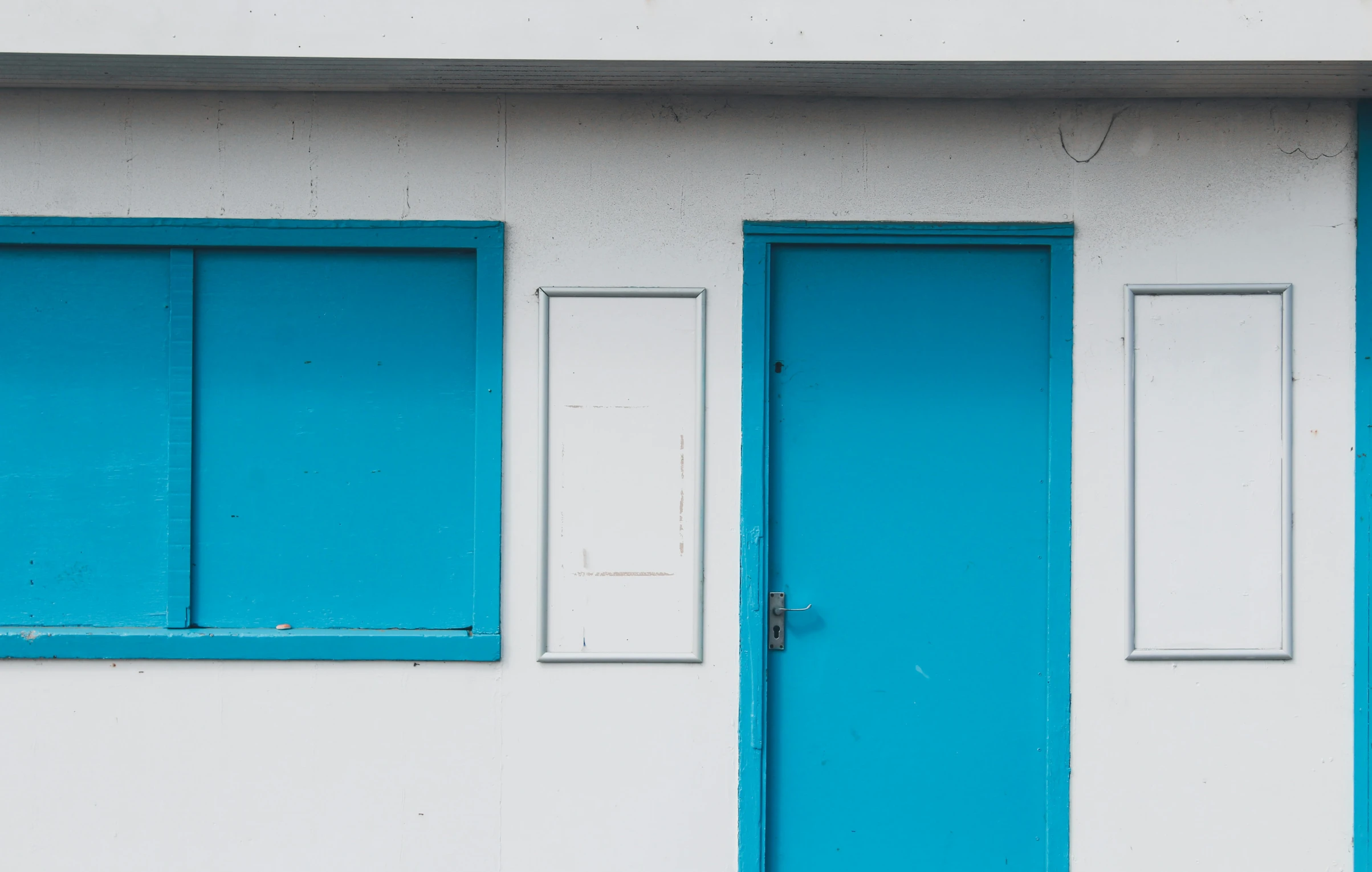 the front and side of a white house with blue shutters