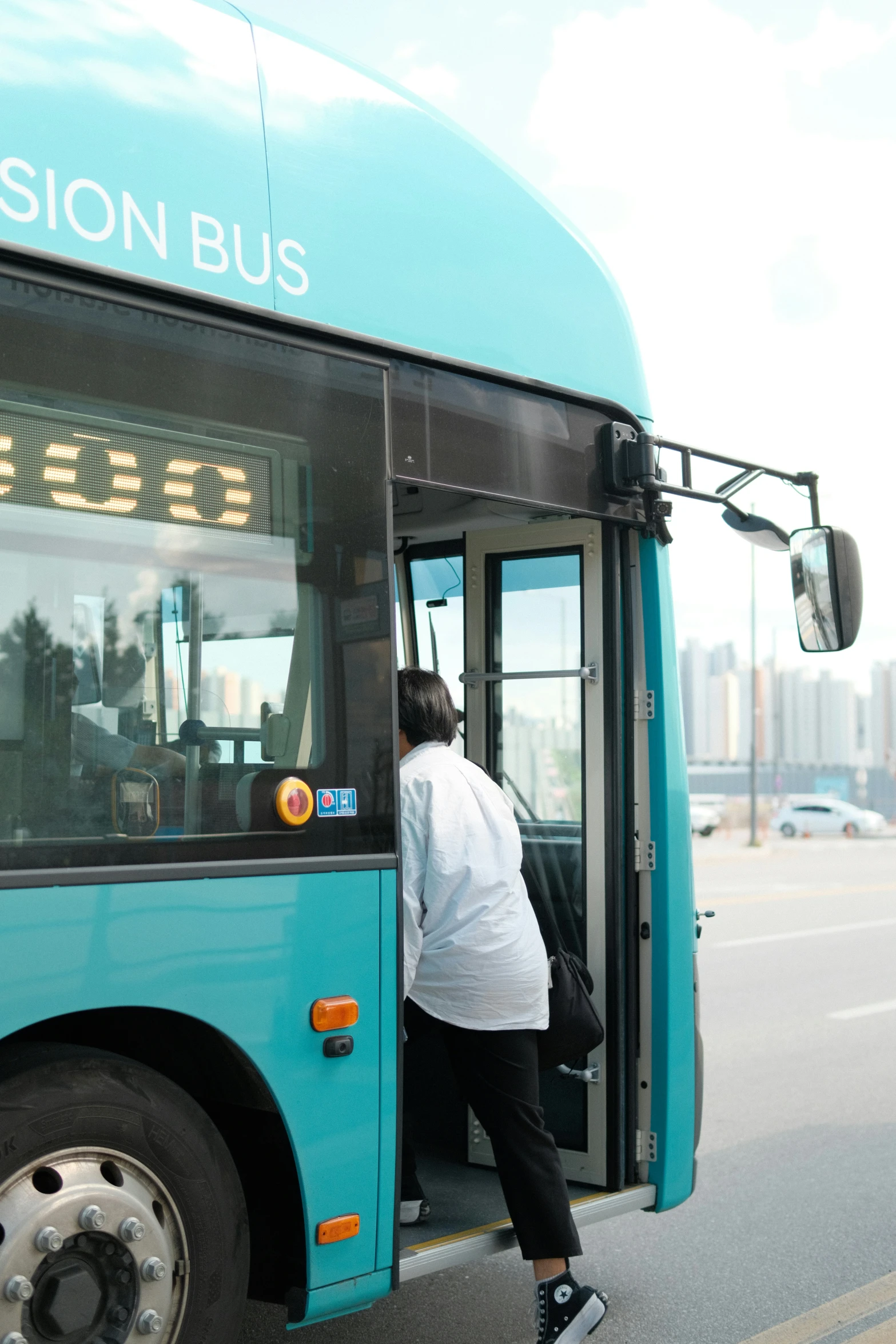 a woman leaning against a bus that reads madison bus