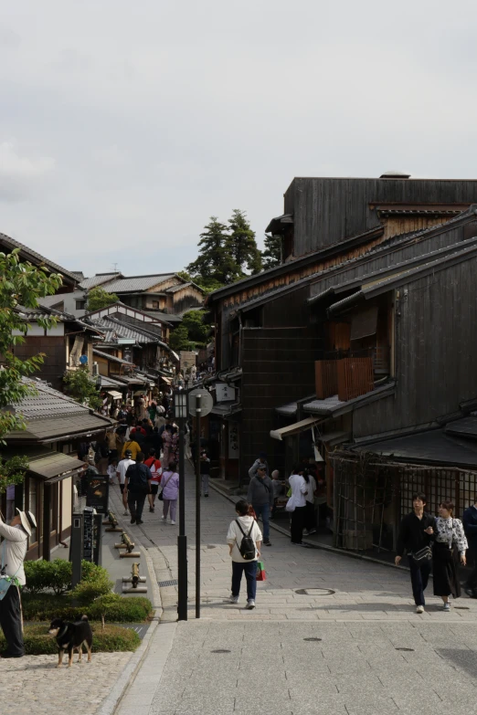 people walk and ride their skateboards down a cobble stone street