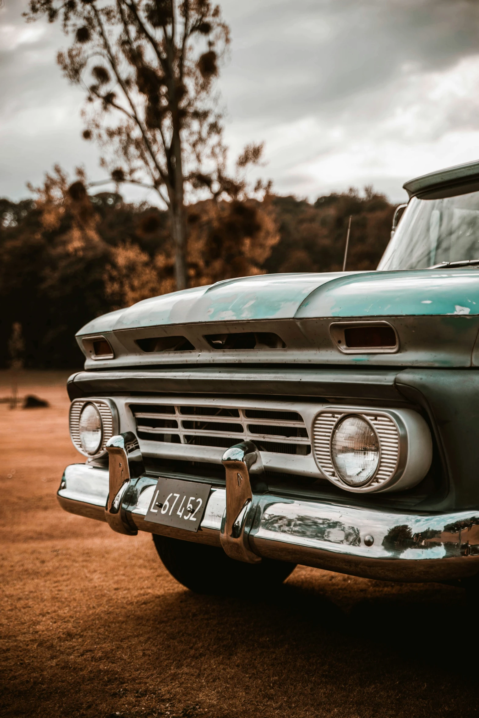 an old style truck with a flat bed parked in a dirt lot