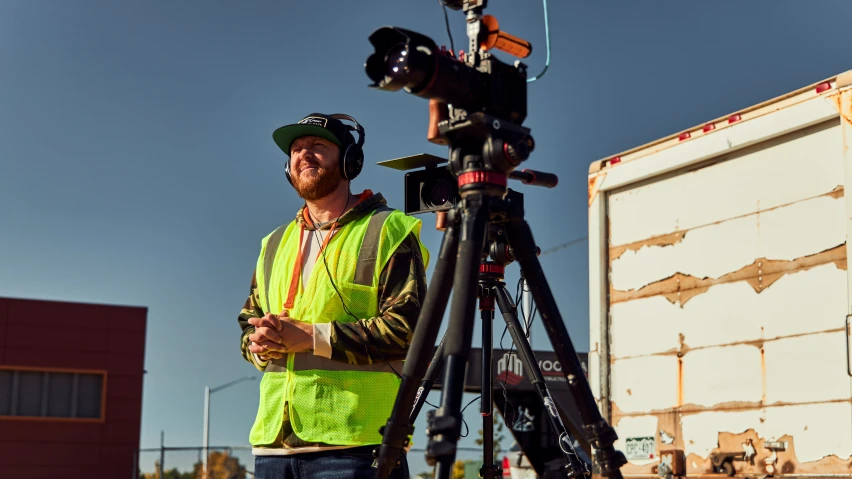 a camera is standing on a tripod next to an object