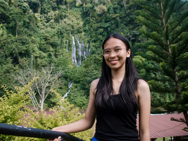 a woman is standing with a forest in the background