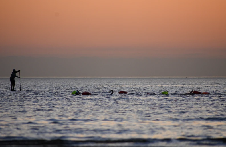 a man standing on a surfboard with his head in the water