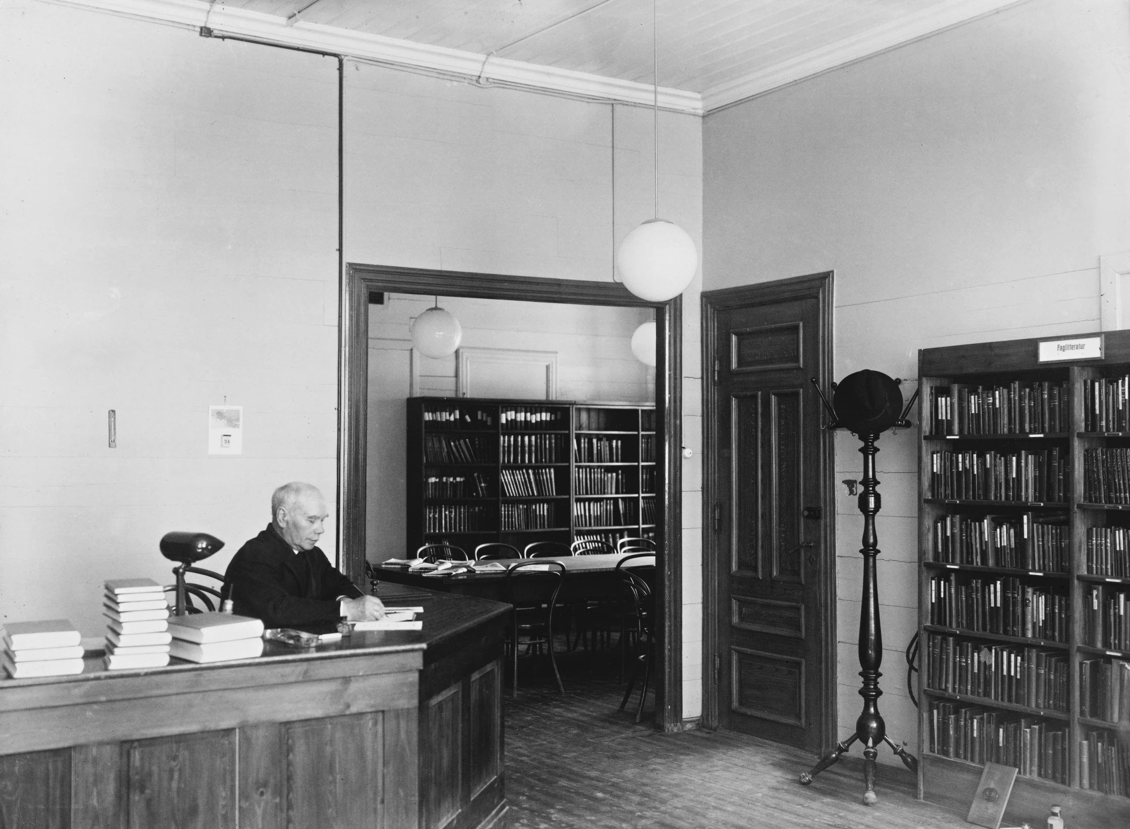 a man sitting at his desk in front of a bookcase