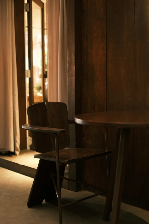 the small wooden chair is next to the large table