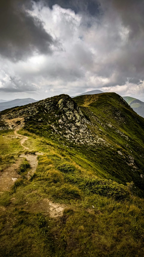 a grassy hill with a dirt path leading up to it