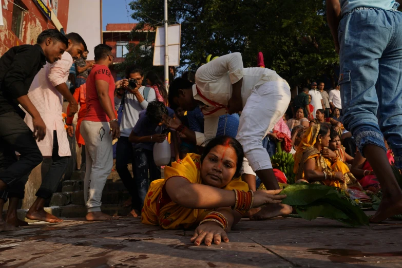 a woman laying on the ground in front of other people
