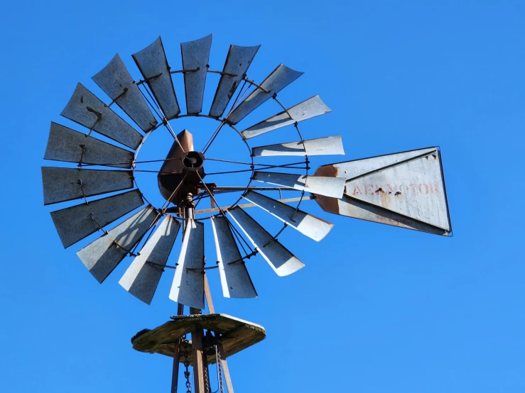 an old windmill is on top of a tall pole