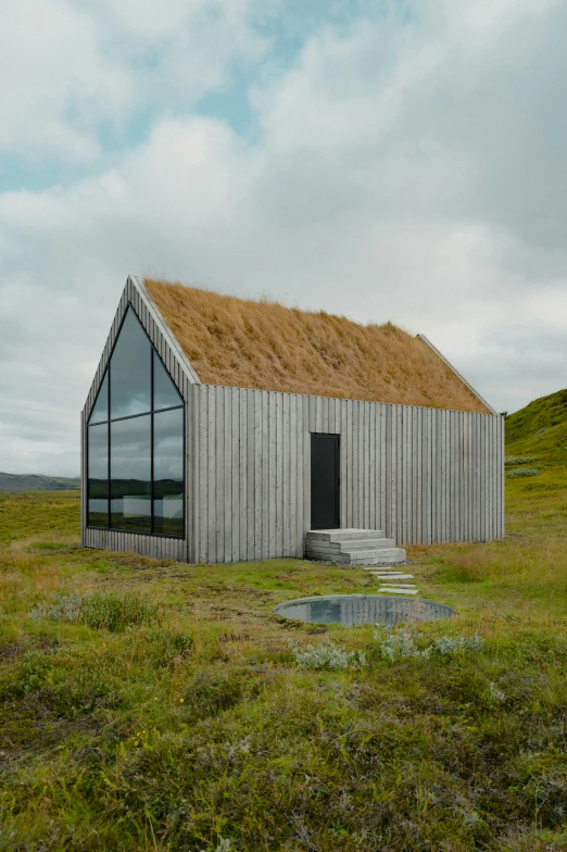 a building made out of wood and glass with grass covering it