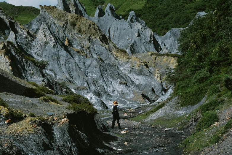 a man in black and white is walking in front of mountains