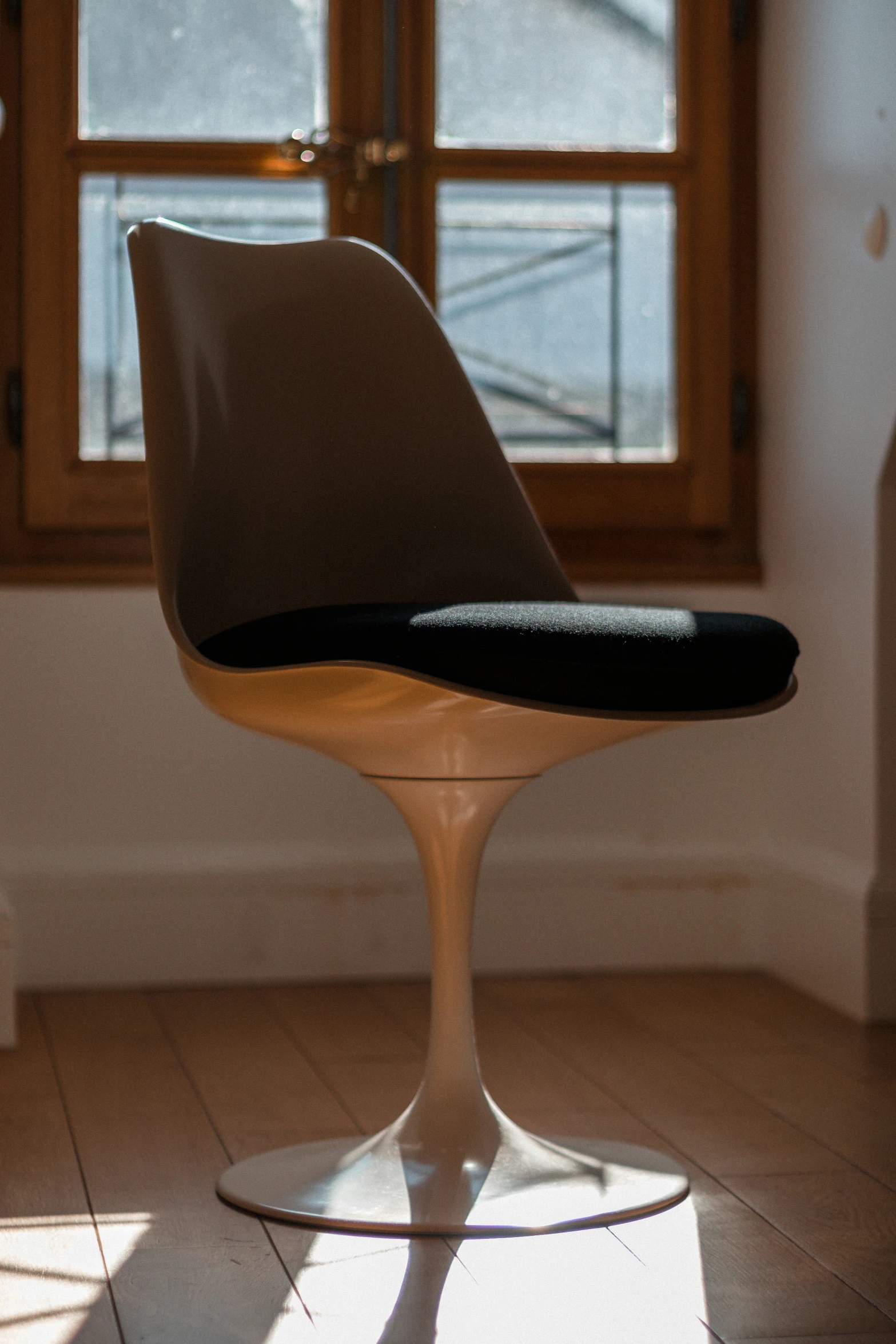 a small black and tan chair sitting in front of a window