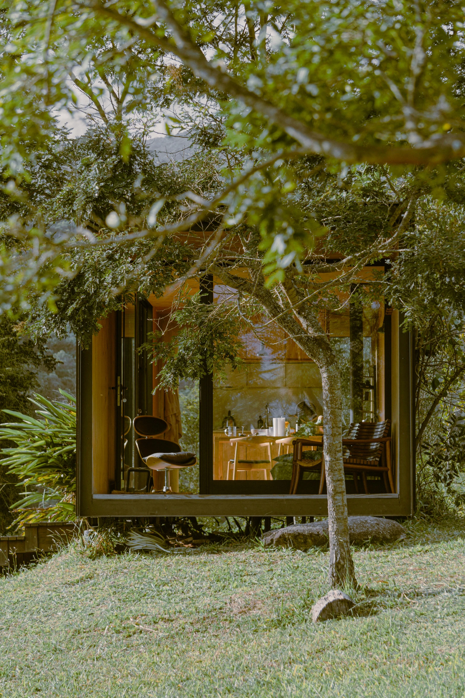 a small cabin sitting among trees and bushes