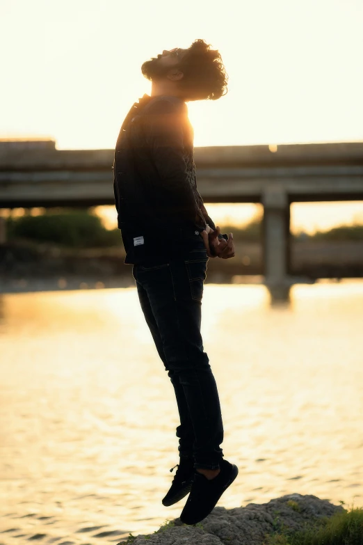 a man stands on a cliff near the water