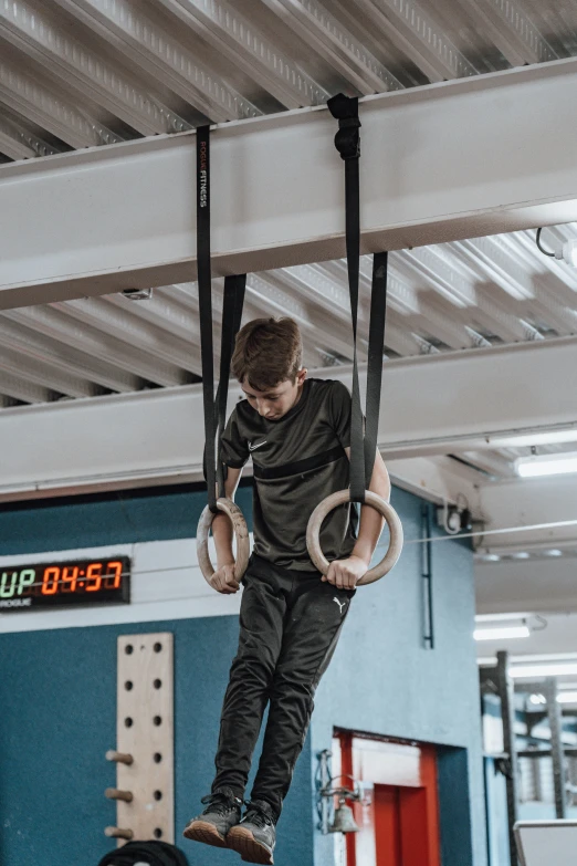 a man hanging upside down on rings inside of an arena