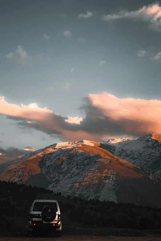 a vehicle is parked beneath the mountain range