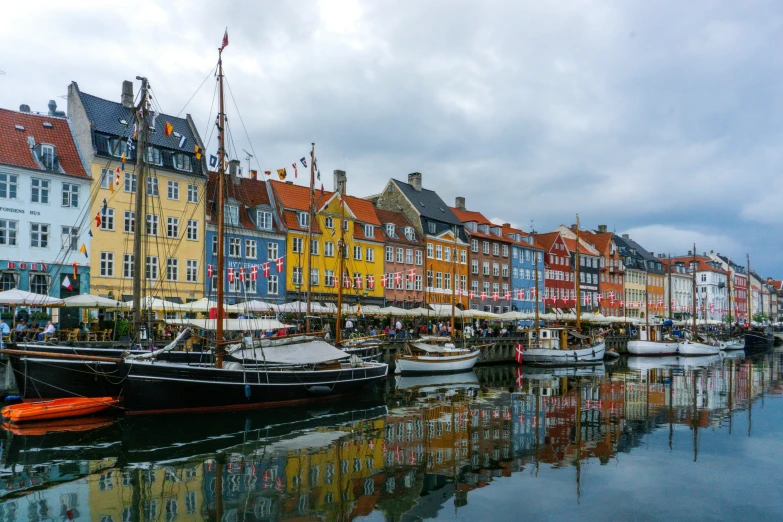 a canal with several boats parked on it in the rain