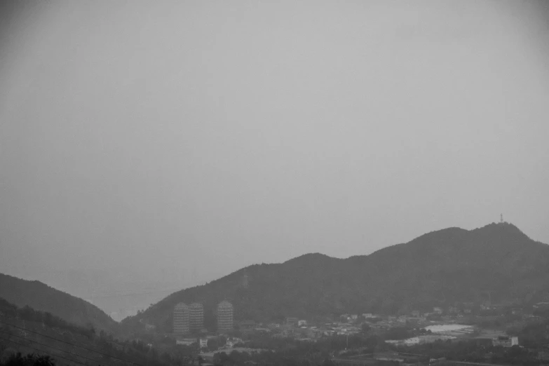 a man on a beach holds his umbrella up as he walks near a mountain range