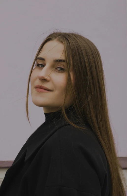 a woman in a black coat posing with a very long hair