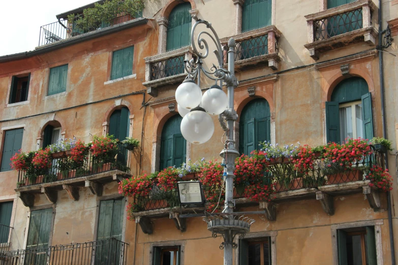 an elaborate street light and flowers near an ornate building