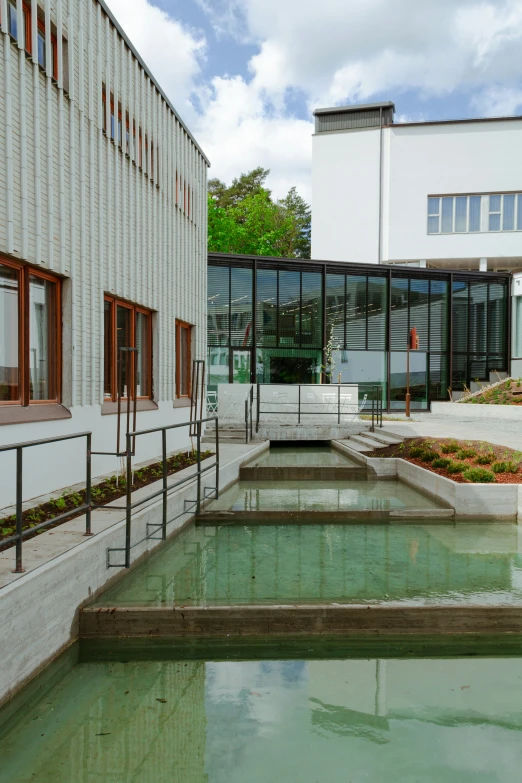 a building with a large green pond outside it