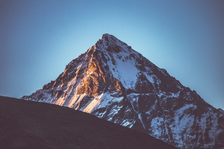 the top of a mountain with clouds above