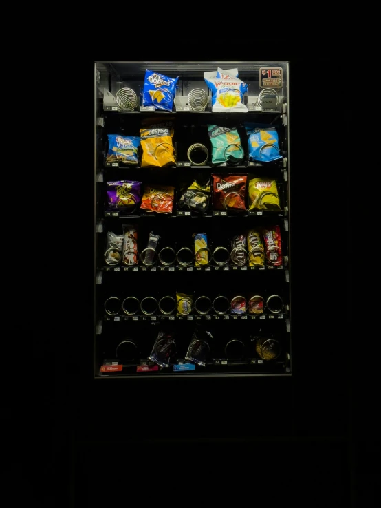 the vending machine has chips, snacks and cups on it