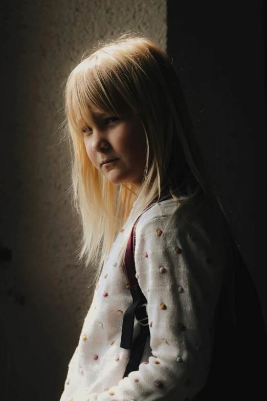 a blond girl is looking straight into the distance