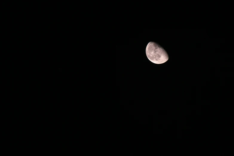 a large moon in the dark night sky with no stars