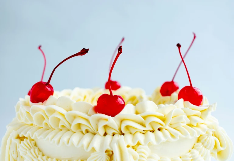 an image of three cherry topped desserts on a cake