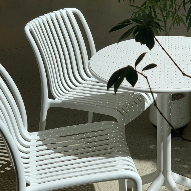 two white plastic chairs and a table