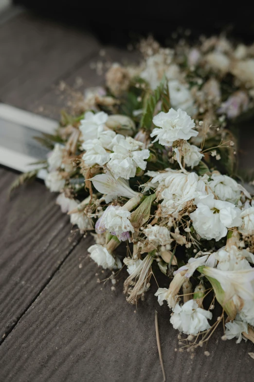 a white bouquet with white flowers on a wooden table