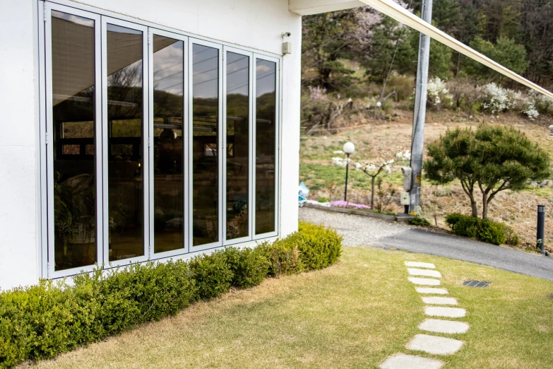 two windows on the front of a building with grass