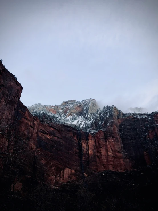 a tall cliff with some snow on top