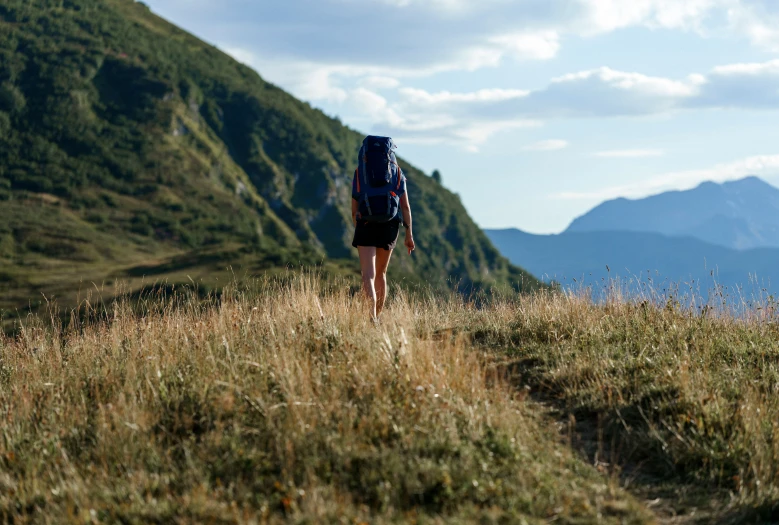 there is a person walking up a hill on the trail